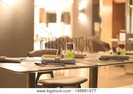 Reserved table in restaraunt close-up. Beautiful restaraunt interior in evening light.