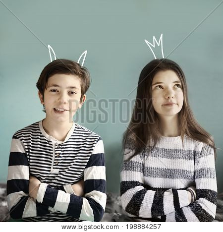teenager brother and sister with demon horns and princess crown drowing close up photo