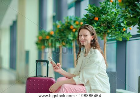 Young woman in international airport walking with her luggage.