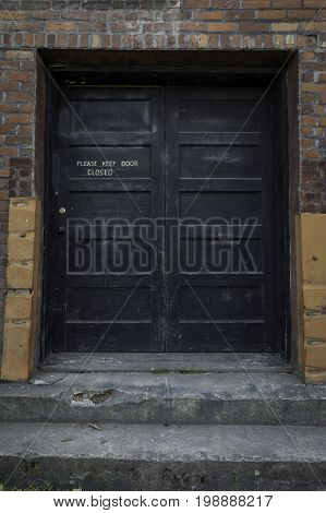 Old black door on an abandoned building
