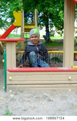 boy playing in the sandbox park outdoor