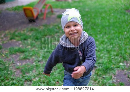 Little boy running down a dirtpath in a beautiful landscape in summer, very light and happy scene