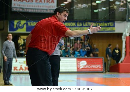 KAPOSVÁR, Hungria - 27 de novembro: Balazs Sabali (treinador Kormend) (em vermelho) em ação em um húngaro C