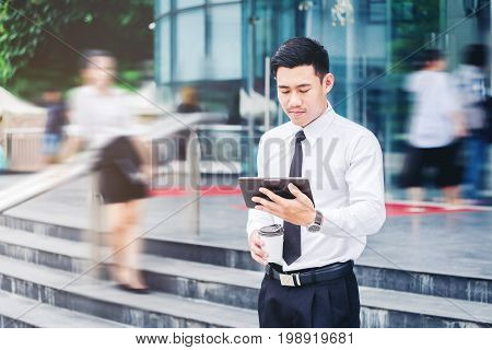 Businessman Using A Digital Tablet Office Outdoors And Blurred People Walking In Front Of Modern Off