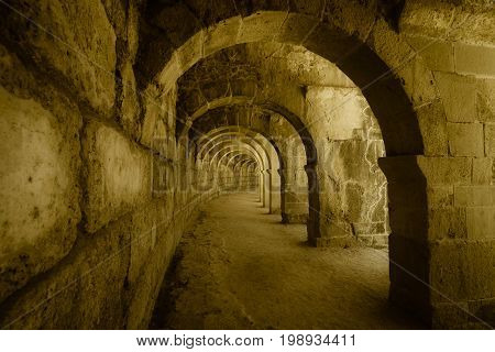 Internal passages in the ancient Roman amphitheater of Aspendos. The province of Antalya. Mediterranean coast of Turkey. Vintage toning. Stylization.