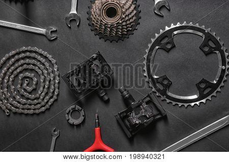 Bicycle parts and repair tools on gray background