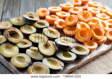 Frozen plums and apricots on a cutting board
