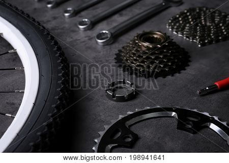 Bicycle parts and repair tools on gray background