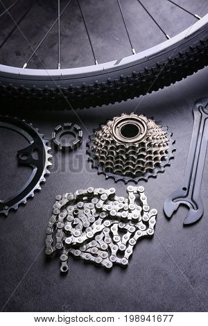 Bicycle parts and tool on gray background