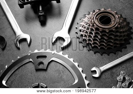 Bicycle parts and repair tools on gray background