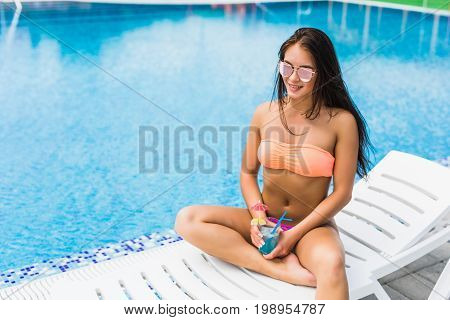 Enjoying Summer. Beautiful Young Woman In Blue Sexy Bikini Drinking Cocktail While Relaxing In Deck