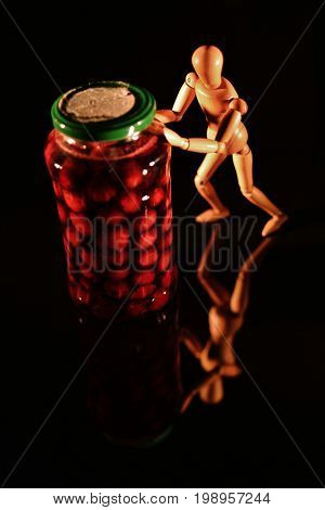 Canned fruit with wooden doll and black background