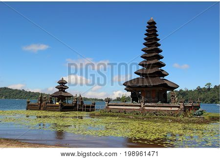 Pura Ulun Danu Bratan Famous Hindu Temple on the Lake at Bedugul on Bali, Indonesia with Blue Sky and a Hill