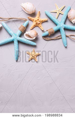 Border from marine items on grey tetured slate background. Sea objects. Selective focus. Place for text.