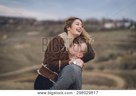 Beautiful Lovely Couple In The Park Or Field Or Track. Man In Coat And Scarf With Girl In Coat. Man 