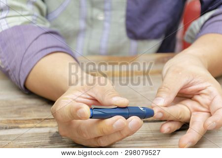 Man Taking Blood Sample With Lancet Pen. Diabetes Concept. Medicine, Diabetes, Glycemia, Health Care