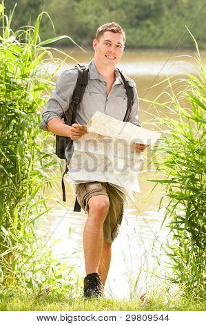 Joven y sonriente backbacker en la naturaleza
