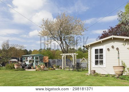 English Garden In Rural East Anglia In Norfolk. Large Outside Private Garden With Trees Potting Shed