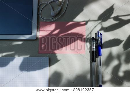 Work Office Space With A Tablet, Notebook, Pens And Headphones Top View, Flat Lay, Copy Space. Pink 