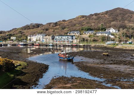 Pier With Buildings And Boat In A Low Tide Clifden Bay