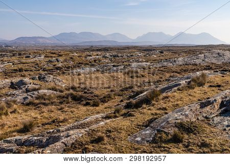 Rocks In A Bog With Twelve Bens Mountains In Background