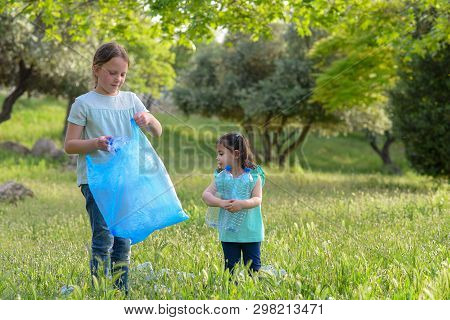 Two Kids Volunteer Charity Environment.children With Garbage Bags Cleaning Up Polluted Environmental