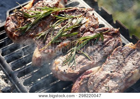 Cooking Outdoors. Juicy Beef Steaks With Rosmary On Grill.