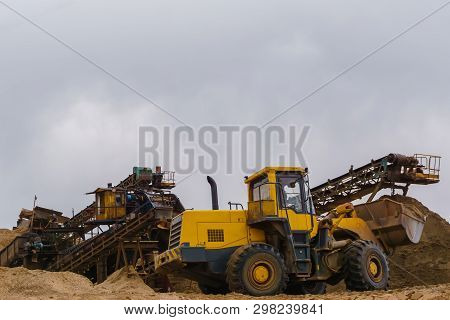 Stationary Rusty Gravitational Sand And Gravel Separator And Bucket Loader On The Background