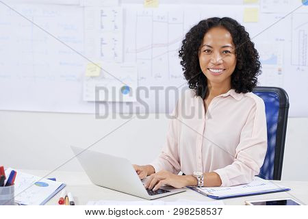 Portrait Of Happy Confident Young Vietnamse Business Lady Working On Laptop At Office Table