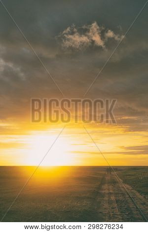 Two Walking Along The Road In The Dunes Of The Baltic Sea At Sunset In Summer