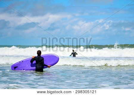 Surfing School. Boy With A Surfboard In His Hands. Surfer Wants To Catch Ocean Wave