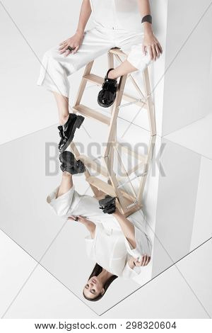 Woman In White Sitting Above Mirror