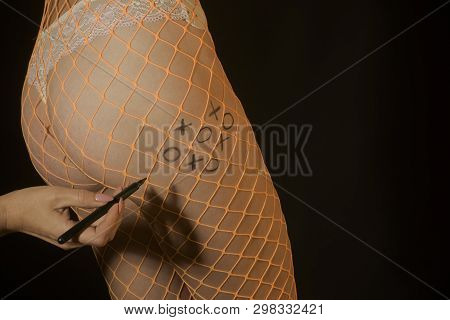 Ass Game. Buttocks In Transparent Pantyhose On The Naked Body. Playing Tic Tac Toe On A Female Body.