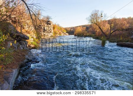 River Section With Rocky Steep Bank In Late Autumn On The Sunset. Buky Canyon, Ukraine