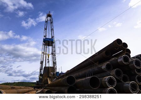 Oil And Gas Drilling Rig Onshore Dessert With Dramatic Cloudscape. Oil Drilling Rig Operation On The