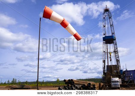 Oil And Gas Drilling Rig Onshore Dessert With Dramatic Cloudscape. Oil Drilling Rig Operation On The