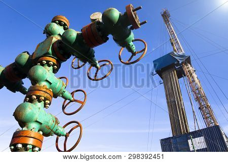 Oil And Gas Drilling Rig Onshore Dessert With Dramatic Cloudscape. Oil Drilling Rig Operation On The