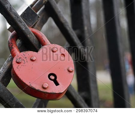 Symbolic love padlocks red color shape heart fixed to the railings bridge as a eternal love sign.