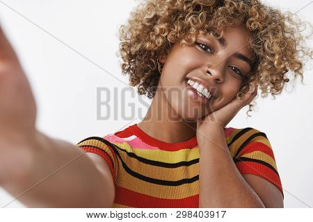 Selfie Shot Of Stylish African American Woman With Pierced Nose And Fair Curly Haircut Tilting Head 