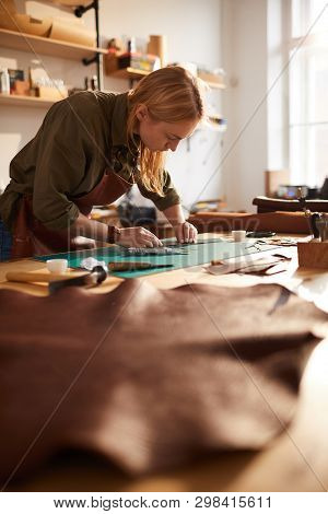 Warm Toned Portrait Of Female Artisan In Leatherworking Atelier Lit By Sunlight, Copy Space