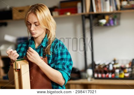Waist Up Portrait Of Young Woman Sewing Leather Bag In Leatherworking Shop, Copy Space