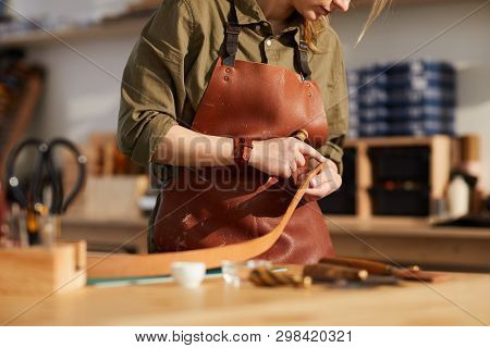 Mid Section Portrait Of Female Craftsman Working With Leather In Tannery Shop, Copy Space