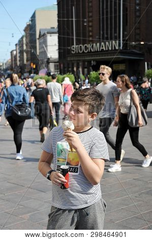 Helsinki, Finland - August 16, 2018: Boy Eating Ice Cream On The Background Of Stockmann In Helsinki