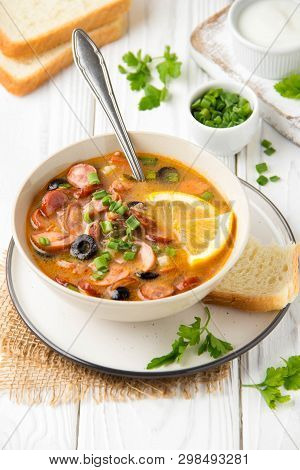 Traditional Russian Soup Solyanka With Beef, Chicken, Sausage, Lemon, Olives And Pickled Cucumber. D