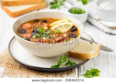Traditional Russian Soup Solyanka With Beef, Chicken, Sausage, Lemon, Olives And Pickled Cucumber. D