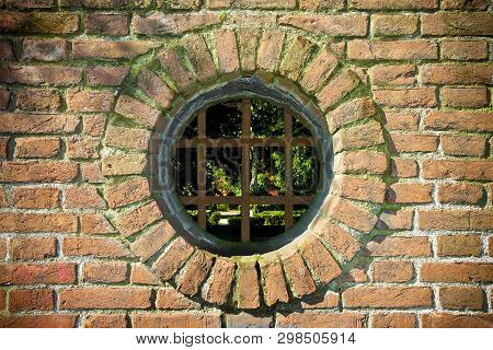 Old Round Window On Rusty Brick Wall With Metal Grate