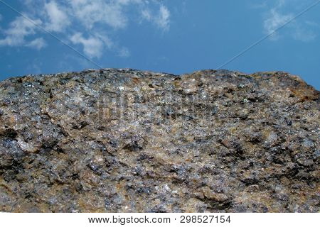 Rock Or Stone On Blue Sky With Clouds Background. Granite Crouan Rim Or Pick Edge Like Cliff Or Moun