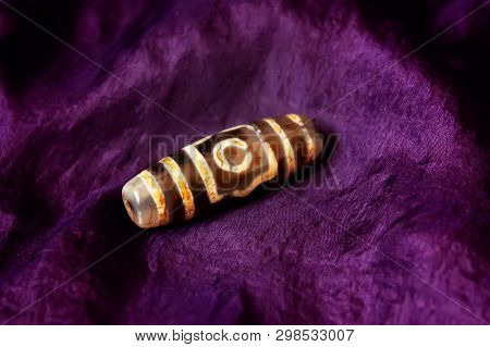 Bracelet : Tibetan Dzi Beads Bracelet, On Blue Background. Dzi Bead Is Considered To Provide Positiv