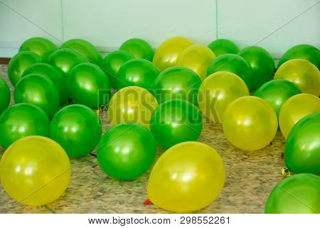 Balloons Of Two Colors Green And Yellow Lie On The Floor.