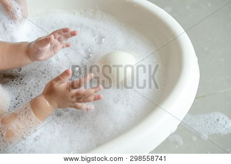 Close Up Baby Girl Plays Bubble In The Water While Bathing